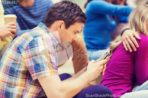 Image of group of smiling students with smartphone