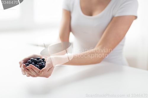 Image of close up of woman hands holding blueberries