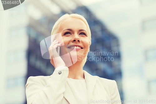 Image of smiling businesswoman with smartphone outdoors