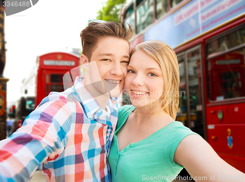 Image of happy couple taking selfie over london city