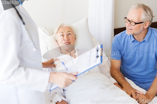 Image of senior woman and doctor with clipboard at hospital