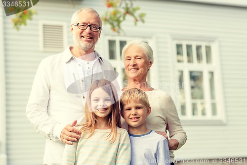 Image of happy family in front of house outdoors