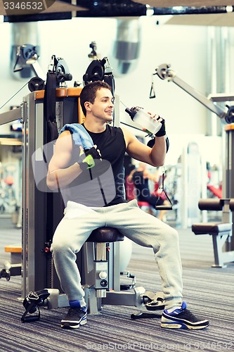 Image of smiling man exercising on gym machine