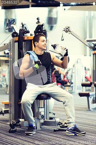 Image of smiling man exercising on gym machine