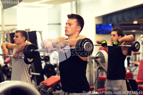 Image of group of men with barbells in gym