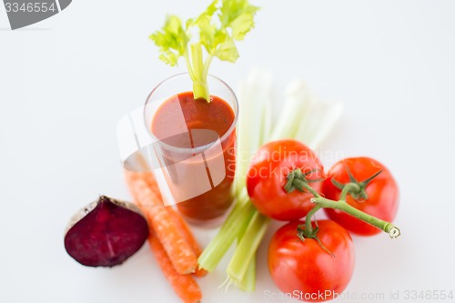 Image of close up of fresh juice and vegetables on table