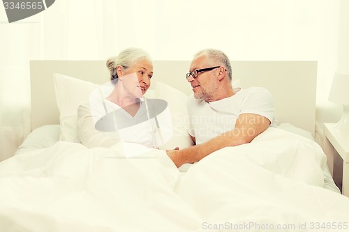 Image of happy senior coupler lying in bad at home