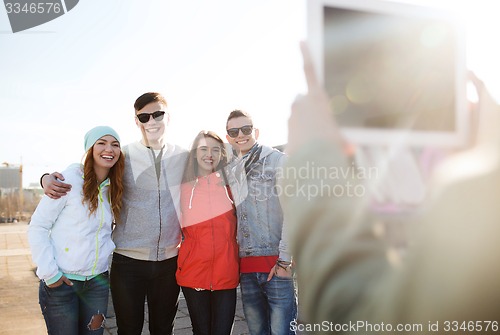 Image of happy teenage friends with tablet pc photographing