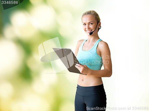 Image of happy woman trainer with microphone and clipboard