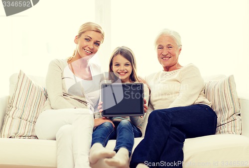 Image of smiling family with tablet pc at home