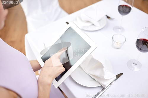 Image of close up of woman with tablet pc at restaurant