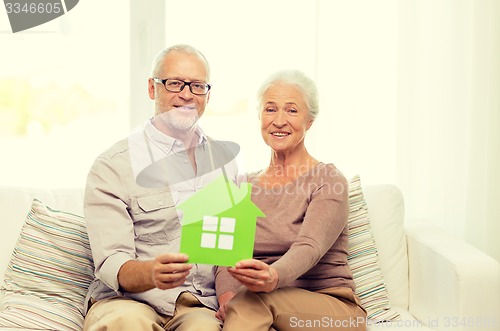 Image of happy senior couple hugging on sofa at home