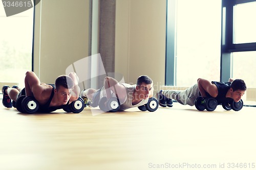 Image of group of men with dumbbells in gym