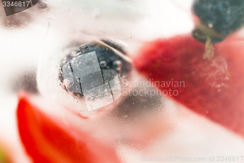 Image of close up of fruit water with ice cubes over glass