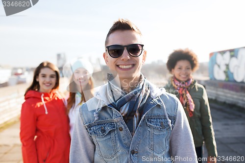 Image of group of happy teenage friends on city street
