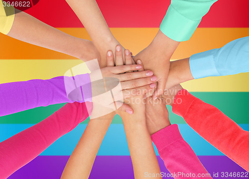 Image of close up of women with hands on top over rainbow