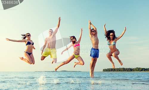 Image of smiling friends in sunglasses on summer beach