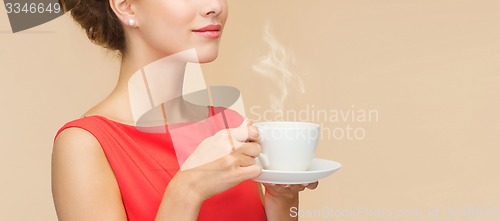 Image of smiling woman in red dress with cup of coffee