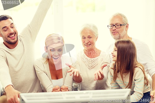 Image of happy family watching tv at home