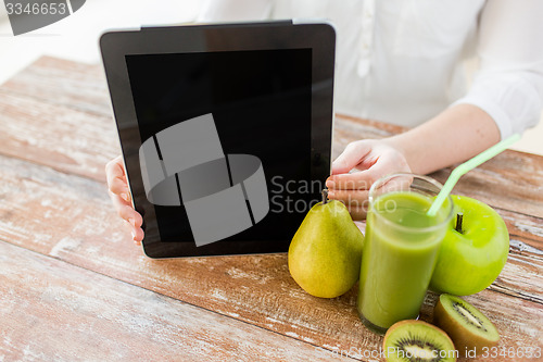 Image of close up of woman hands tablet pc and fruit juice