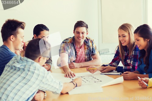 Image of group of smiling students with blueprint