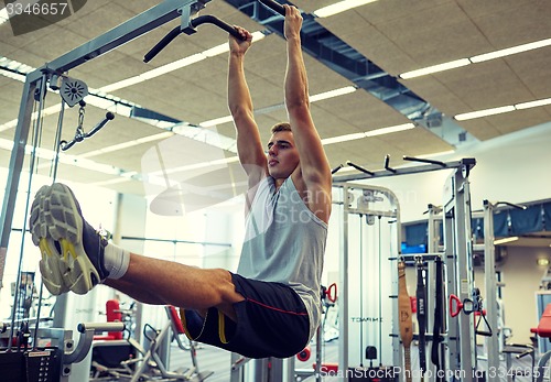 Image of man flexing abdominal muscles on pull-up bar