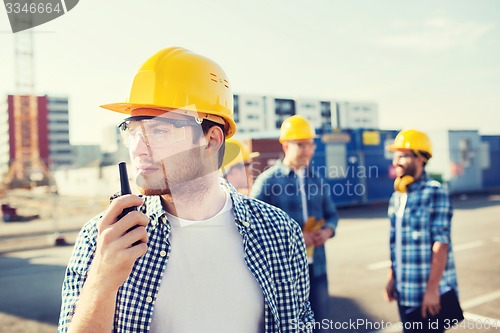 Image of group of builders in hardhats with radio