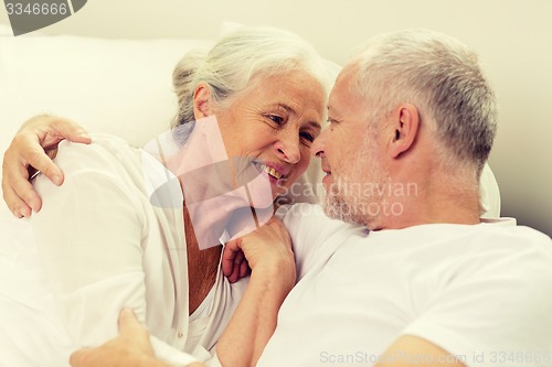 Image of happy senior coupler lying in bad at home