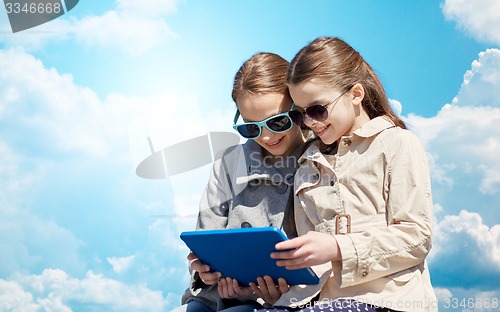 Image of happy girls with tablet pc computer over blue sky