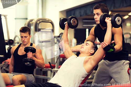 Image of group of men with dumbbells in gym