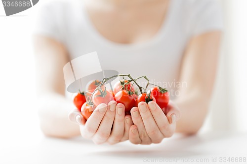 Image of close up of woman hands holding cherry tomatoes