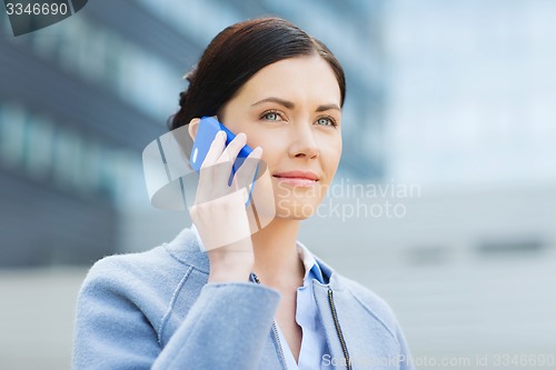 Image of young smiling businesswoman calling on smartphone