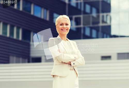 Image of young smiling businesswoman with crossed arms
