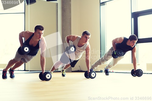 Image of group of men with dumbbells in gym