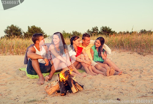 Image of smiling friends in sunglasses on summer beach