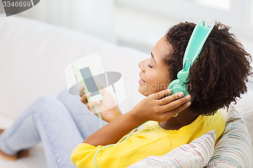 Image of happy african woman with smartphone and headphones