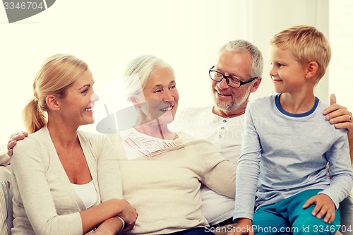 Image of happy family sitting on couch at home