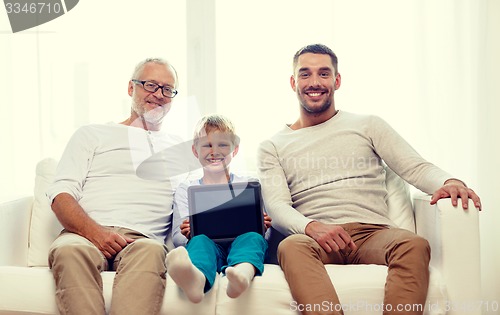 Image of smiling family with tablet pc at home
