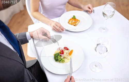 Image of close up of couple eating appetizers at restaurant