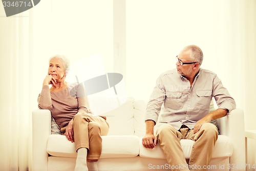 Image of senior couple sitting on sofa at home