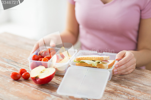 Image of close up of woman with food in plastic container