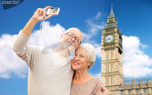 Image of senior couple taking selfie on camera over big ben