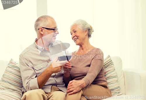 Image of happy senior couple with glasses of red wine