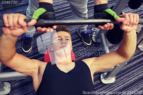 Image of men doing barbell bench press in gym