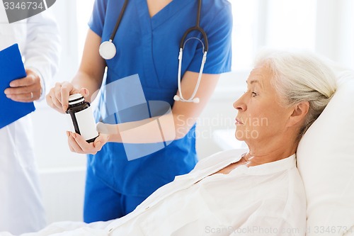 Image of doctor giving medicine to senior woman at hospital