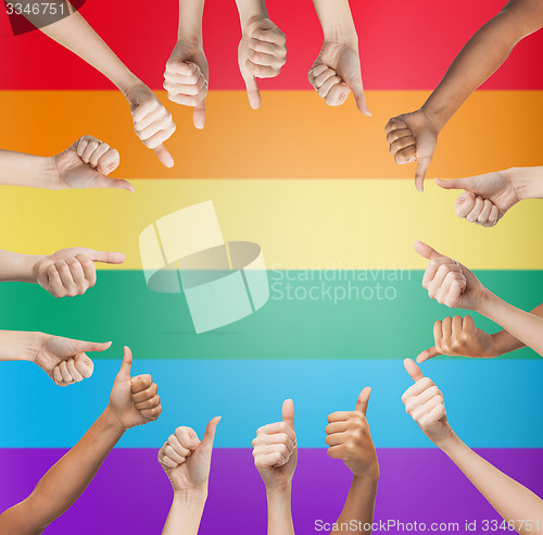 Image of hands showing thumbs up in circle over rainbow