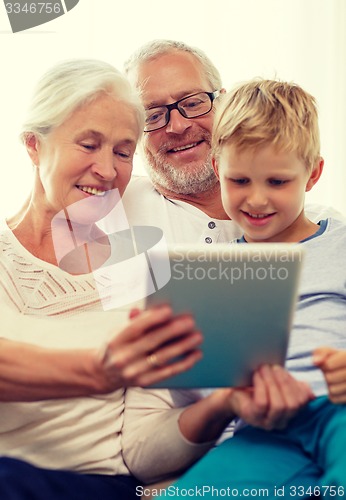 Image of smiling family with tablet pc at home
