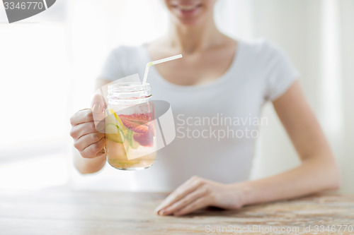 Image of close up of woman holding glass with fruit water