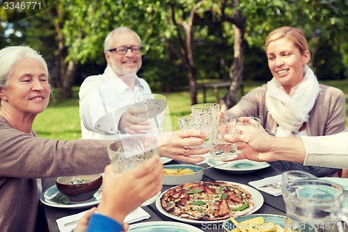 Image of happy family having dinner in summer garden