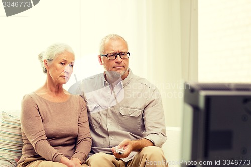 Image of senior couple watching tv at home
